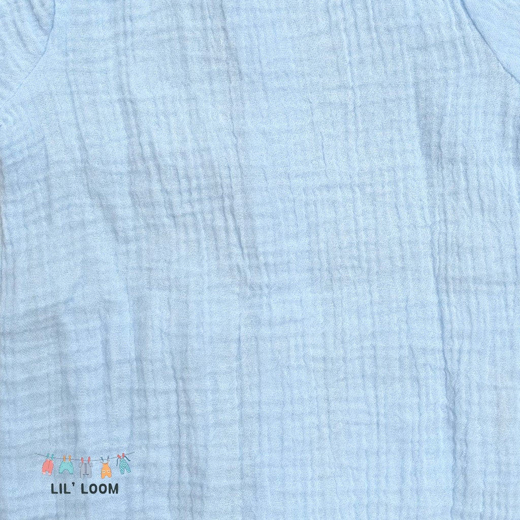 Close-up of light blue textured organic muslin fabric with 'LIL' LOOM' brand logo.