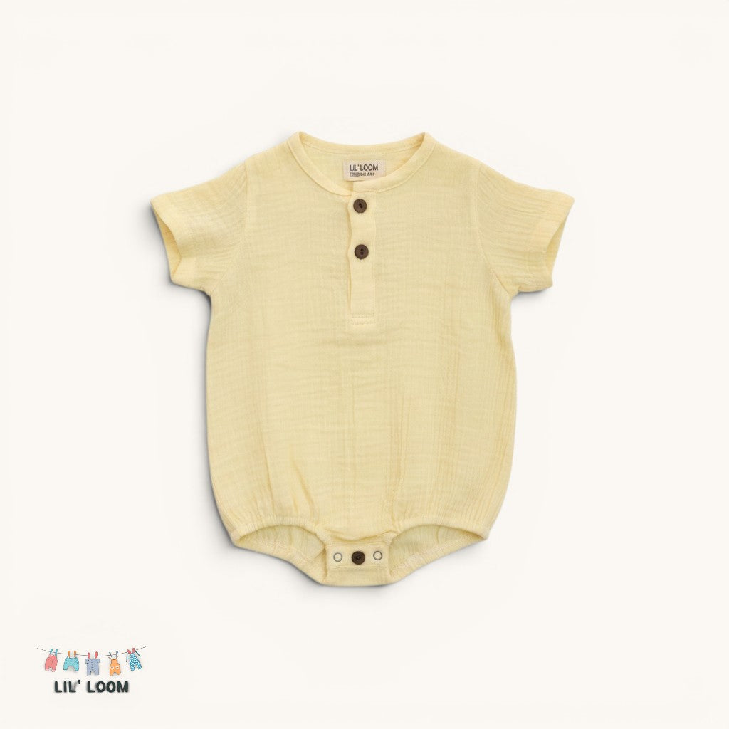 Yellow muslin cotton baby onesie with brown buttons on a white background, featuring the brand 'Lil' Loom'.