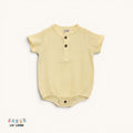 Yellow muslin cotton baby onesie with brown buttons on a white background, featuring the brand 'Lil' Loom'.