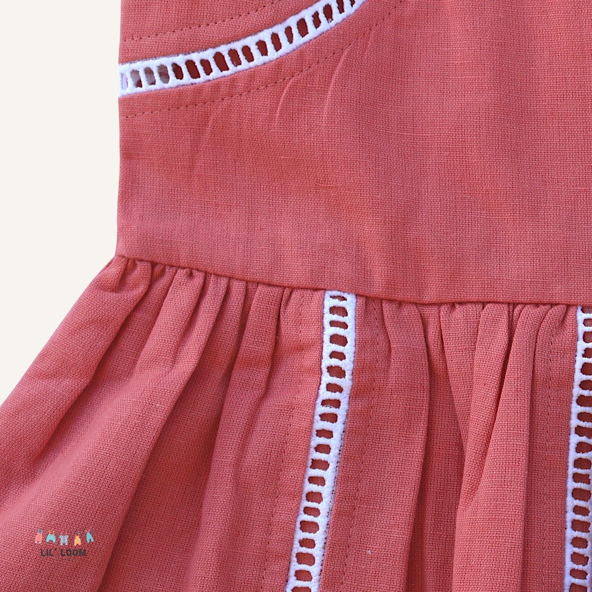 LIL' LOOM coral cotton candy strap dress with white eyelet trim and gathered skirt.