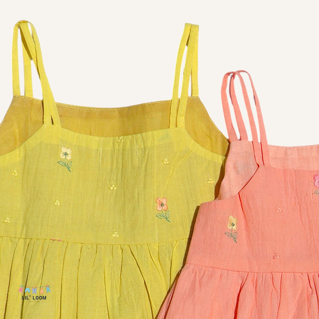 Yellow and pink dresses with floral embroidery on a white background