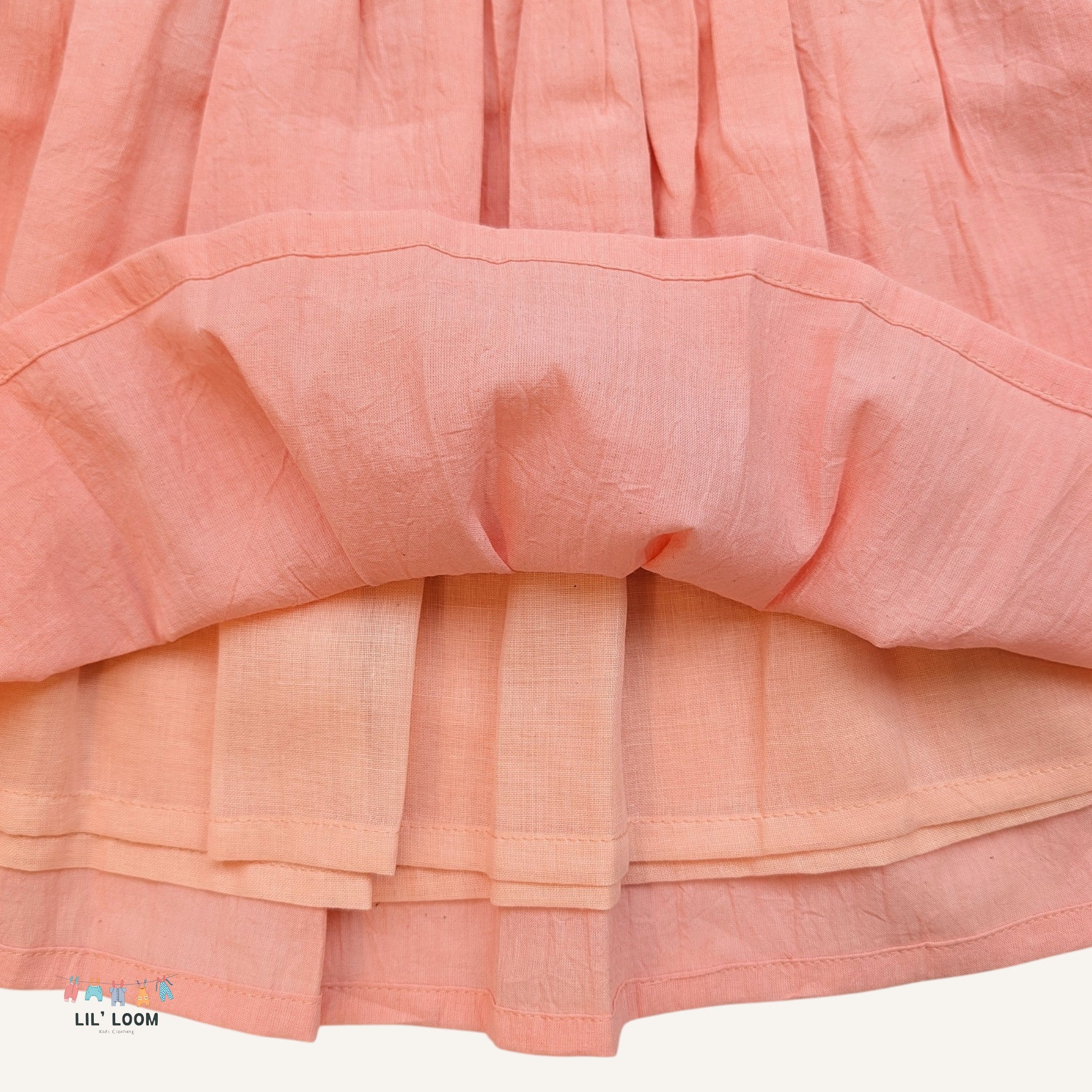 Close-up of a pink skirt with ruffled layers on a white background